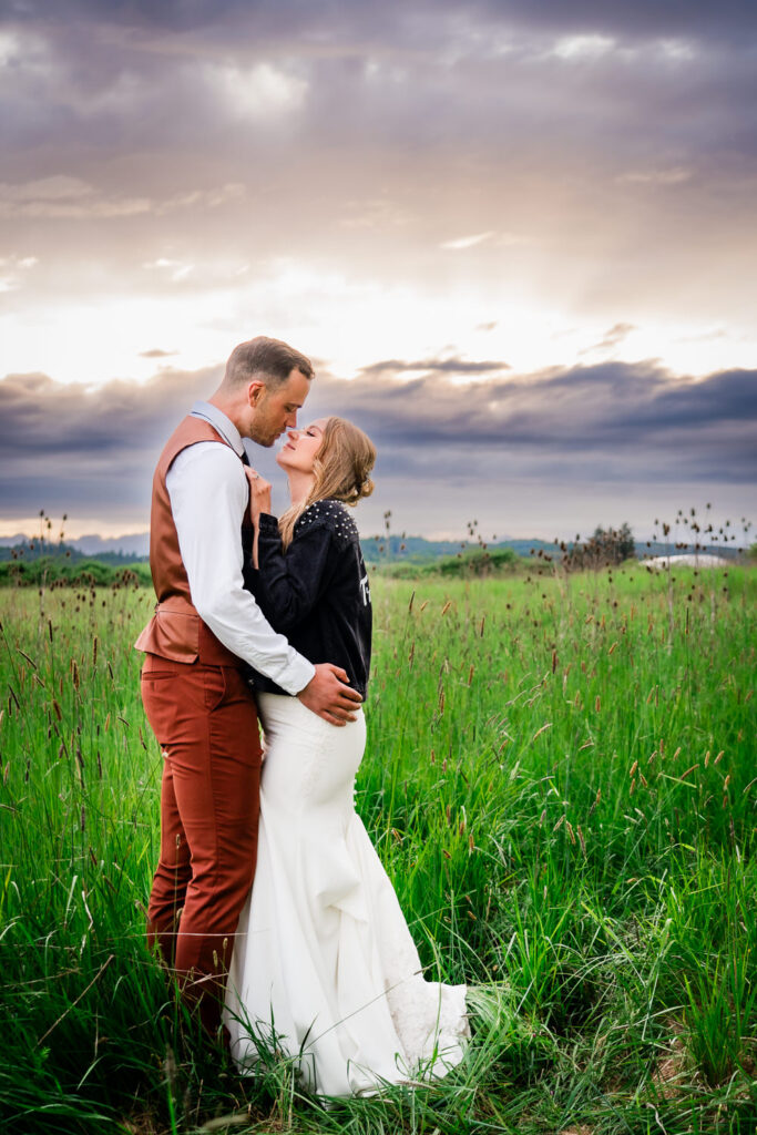 Water Oasis Wedding Portrait of Bride and Groom in the meadow with wine country hills in distance
